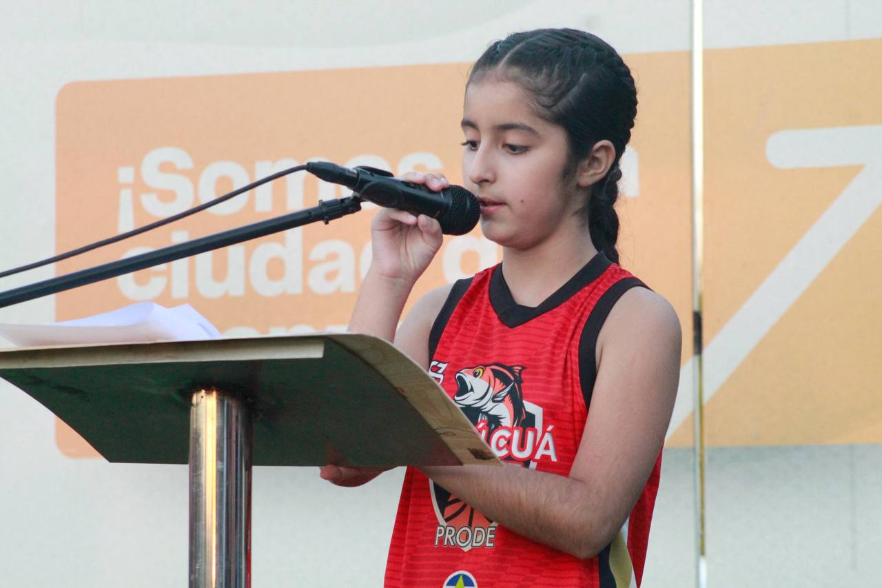 Niña hablando en el micrófono durante evento de PRODE
